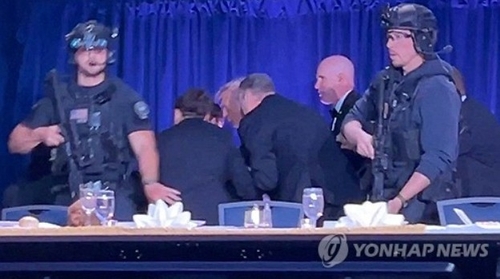 비밀경호국 요원들에 의해 만찬장을 빠져나가는 트럼프 대통령 모습
