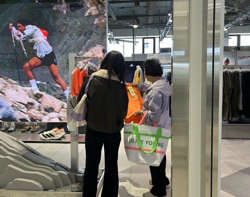 무신사 메가스토어 성수 매장에서 올리브영 쇼핑백을 들고 있는 한 고객