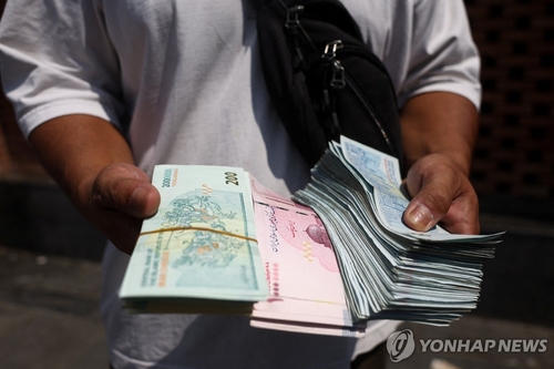 이란 수도 테헤란의 그랜드 바자르에서 리알화를 들고 있는 환전상