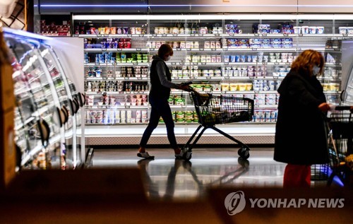 (FILES) This file photo taken on April 29, 2020 shows a customer pushing a shopping cart past the shelves of a supermarket in Duesseldorf, western Germany. - German consumer confidence remains on a record downward slide as Europe's largest economy faces soaring inflation and an energy crisis heading into winter, a key survey published on September 28, 2022 showed. (Photo by Ina FASSBENDER / AFP)
