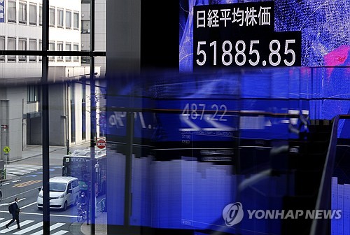 epa12859780 A stock indicator board is displayed inside a building as the traffic passes by a street crossing in Tokyo, Japan, 30 March 2026. EPA/FRANCK ROBICHON