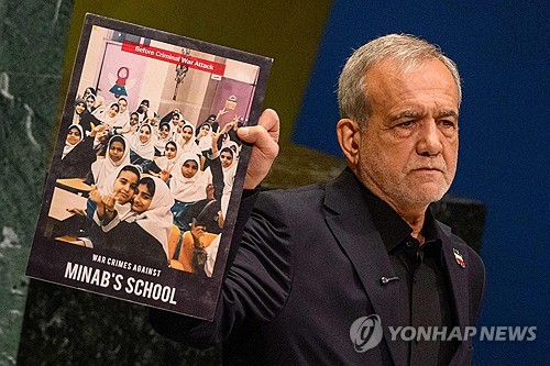 유엔총회 연설 중 미국의 공습에 희생된 학생들의 사진을 들어 보이는 마수드 페제시키안 이란 대통령