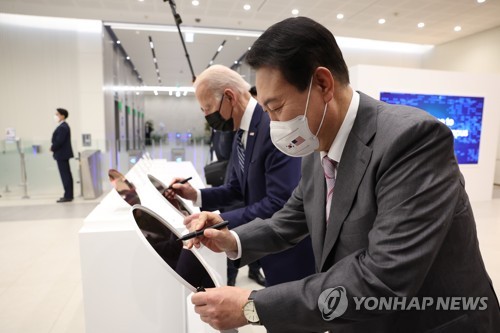 (평택=연합뉴스) 안정원 기자 = 취임 후 한국을 첫 방문한 조 바이든 미국 대통령이 윤석열 대통령과 20일 오후 경기도 평택시 삼성전자 반도체공장을 방문, 조만간 양산에 돌입하는 차세대 GAA(Gate-All-Around) 기반 세계 최초 3나노 반도체 시제품에 사인하고 있다. 2022.5.20 jeong@yna.co.kr