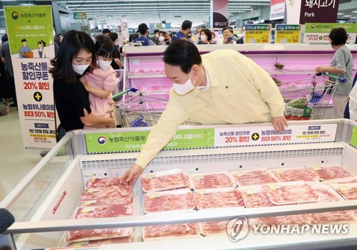 (서울=연합뉴스) 안정원 기자 = 물가동향 점검에 나선 윤석열 대통령이 11일 서울 서초구 양재동 하나로마트 양재점에서 한 시민과 삼겹살을 살펴보고 있다. 2022.8.11 jeong@yna.co.kr