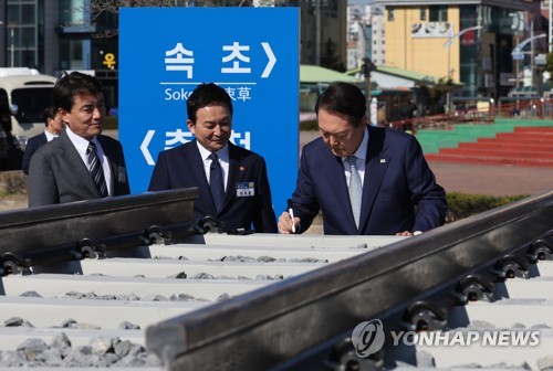 (속초=연합뉴스) 서명곤 기자 = 윤석열 대통령이 18일 오전 속초 엑스포 잔디광장에서 열린 '춘천~속초 동서고속화철도' 착공 기념식에 참석, 침목에 서명하고 있다. 2022.10.18 seephoto@yna.co.kr