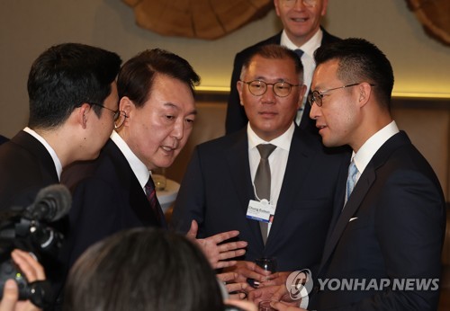 (다보스=연합뉴스) 임헌정 기자 = 다보스포럼 참석차 스위스를 방문 중인 윤석열 대통령이 18일(현지시간) 다보스 시내 한 호텔에서 열린 '글로벌 CEO와의 오찬'에서 정의선 현대차그룹 회장(가운데), 존 리아디 리포 까라와찌 최고경영자(CEO)와 대화하고 있다. 2023.1.18 kane@yna.co.kr