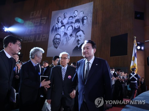 (서울=연합뉴스) 안정원 기자 = 윤석열 대통령과 김건희 여사가 1일 서울 중구 유관순 기념관에서 열린 제104주년 3.1절 기념식에 김영관 애국지사와 함께 입장하고 있다. 2023.3.1 jeong@yna.co.kr