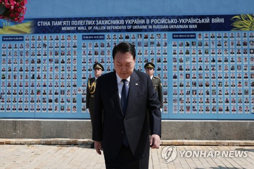 (키이우=연합뉴스) 임헌정 기자 = 폴란드 수도 바르샤바에서 국빈급 공식 방문 일정을 마치고 우크라이나를 전격 방문한 윤석열 대통령이 15일(현지시간) 키이우 전사자 추모의 벽을 찾아 묵념하고 있다. 2023.7.15 [대통령실 제공. 재판매 및 DB 금지] kane@yna.co.kr