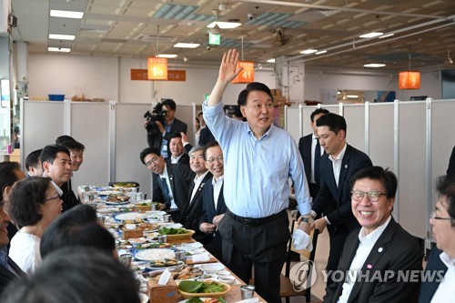 (부산=연합뉴스) 진성철 기자 = 윤석열 대통령이 27일 부산 중구 자갈치시장 2층 식당에서 저녁식사 도중 손님들에게 인사하고 있다.   2023.7.28 [대통령실 제공. 재판매 및 DB 금지] zjin@yna.co.kr