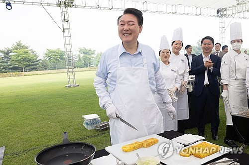 (서울=연합뉴스) 홍해인 기자 = 윤석열 대통령이 24일 서울 용산 대통령실 청사 잔디마당에서 열린 ‘대통령의 저녁 초대’  출입기자단 초청 만찬 간담회에서 계란말이를 만들고 있다. 2024.5.24 [대통령실 제공. 재판매 및 DB 금지] hihong@yna.co.kr