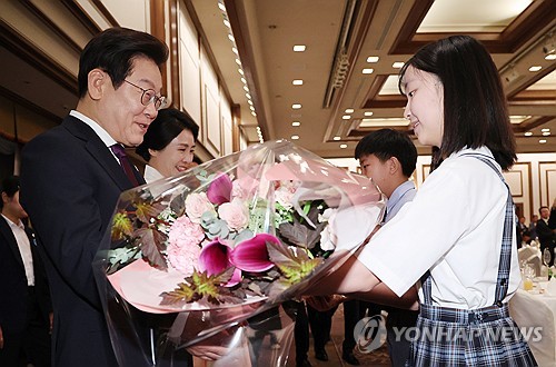 재일동포 간담회, 화동으로부터 꽃다발 받는 이재명 대통령 부부