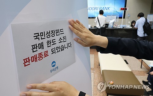 국민참여성장펀드 당시 판매종료 안내문 붙이는 은행직원