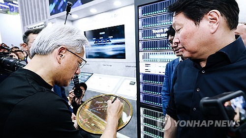 협력 제품 전시물에 사인 남기는 젠슨 황 엔비디아 CEO